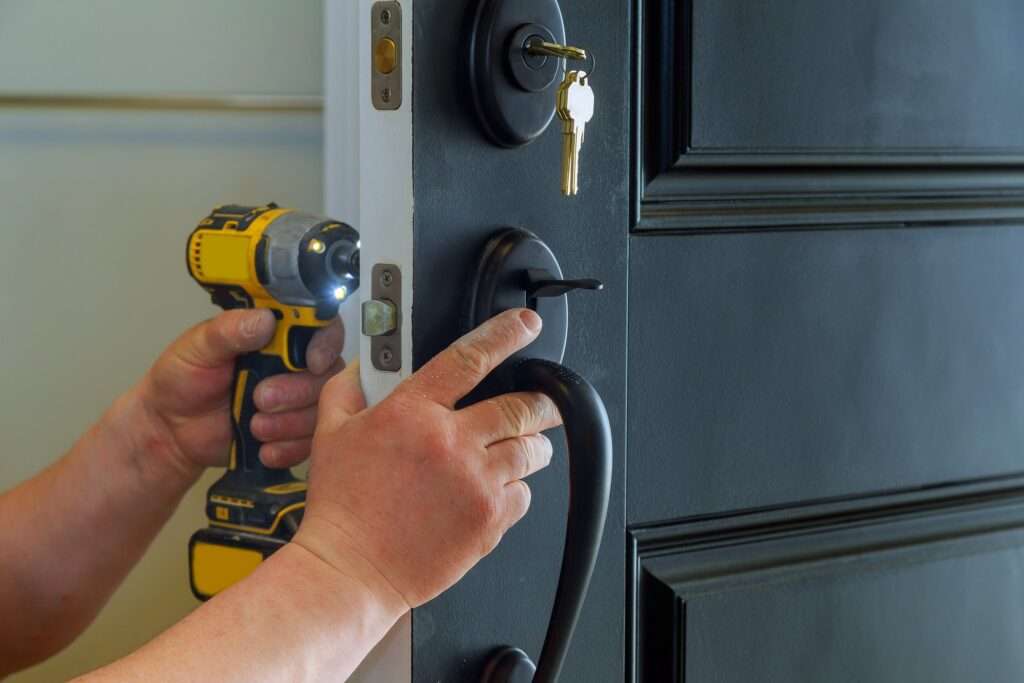 Professional locksmith installing a new lock on a house exterior door with the inside