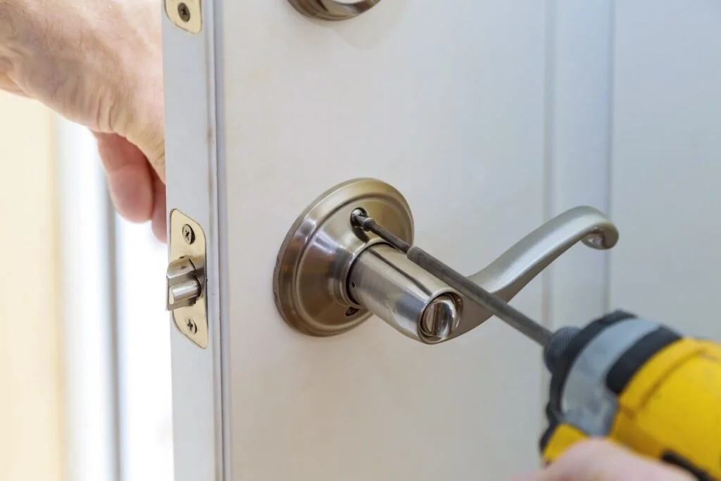 Locksmith installing door lock